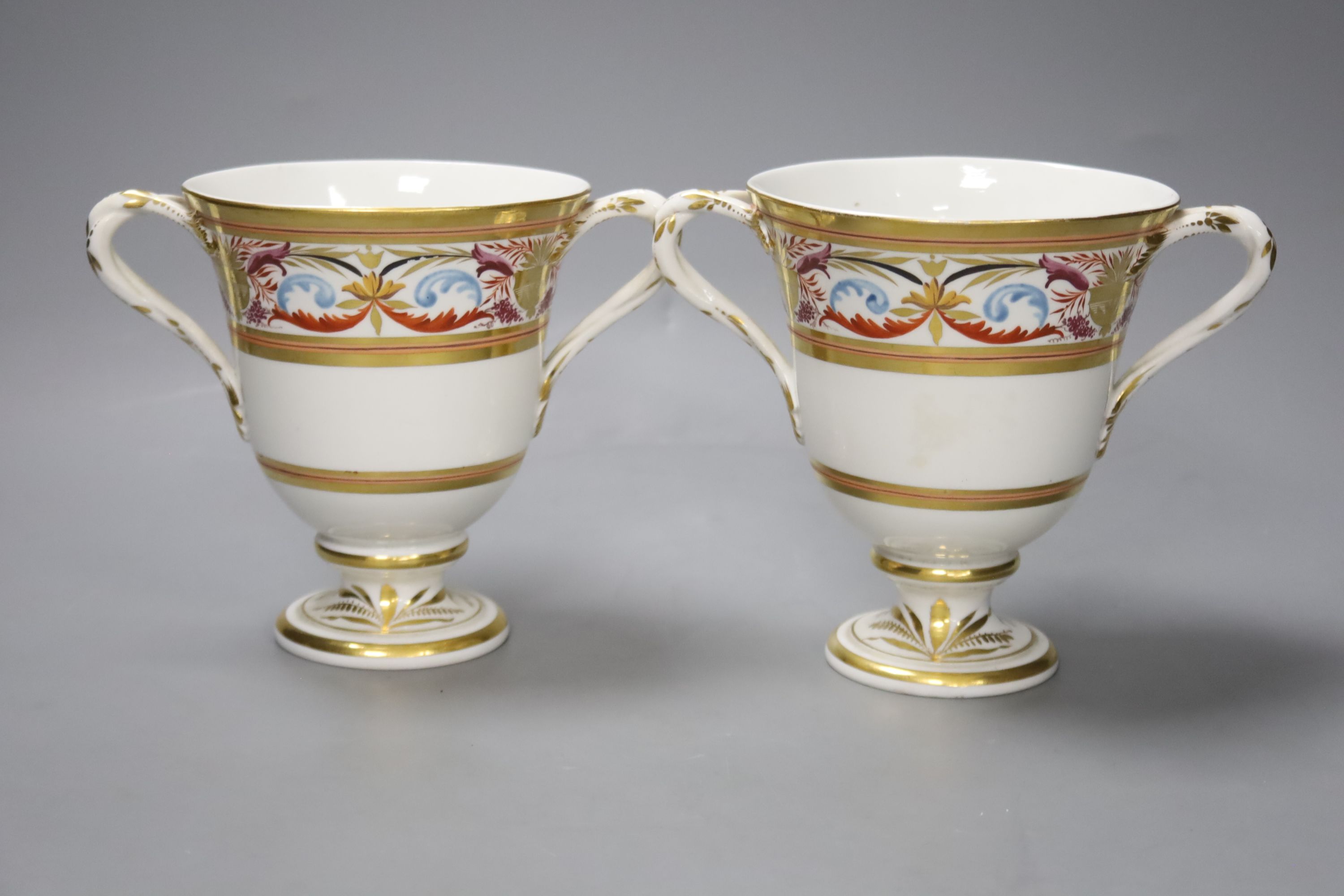 A pair of Derby two handled loving cups, c.1805, painted in arabesque style, pattern no.407, height 14cm